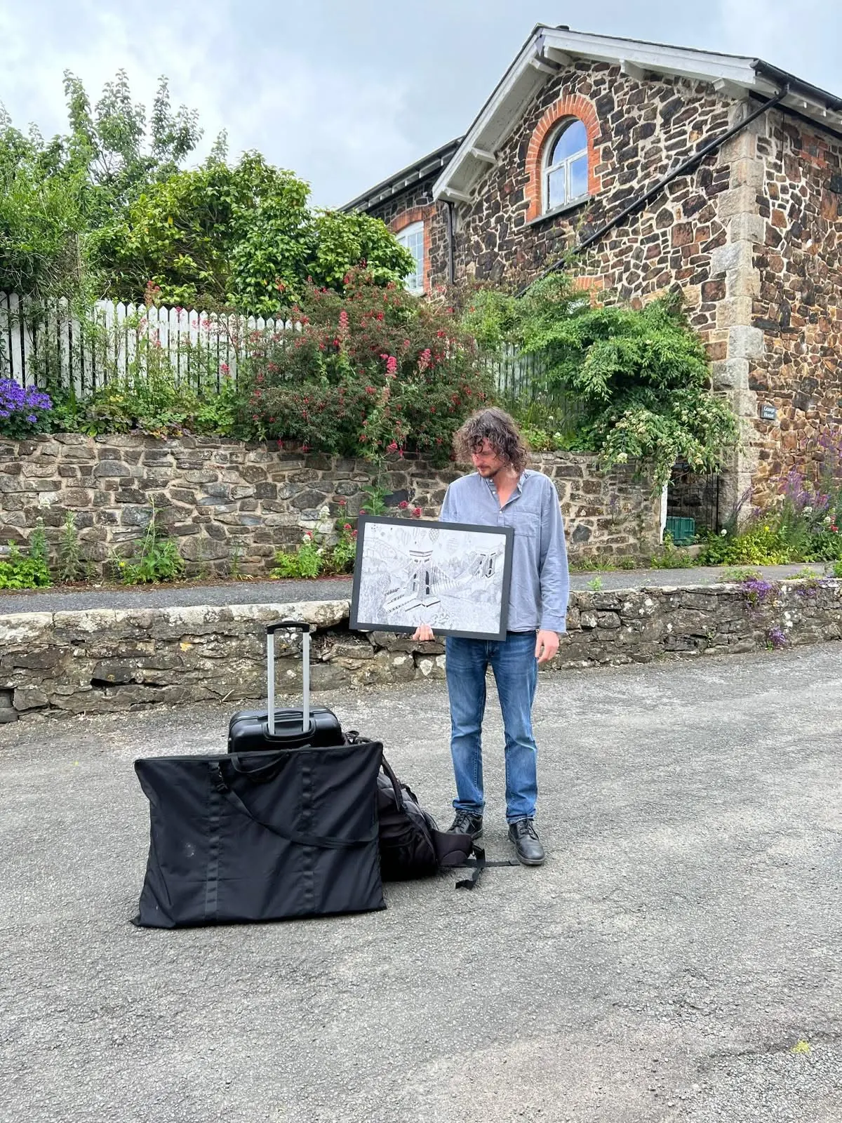 David Furler holding a framed drawing outdoors